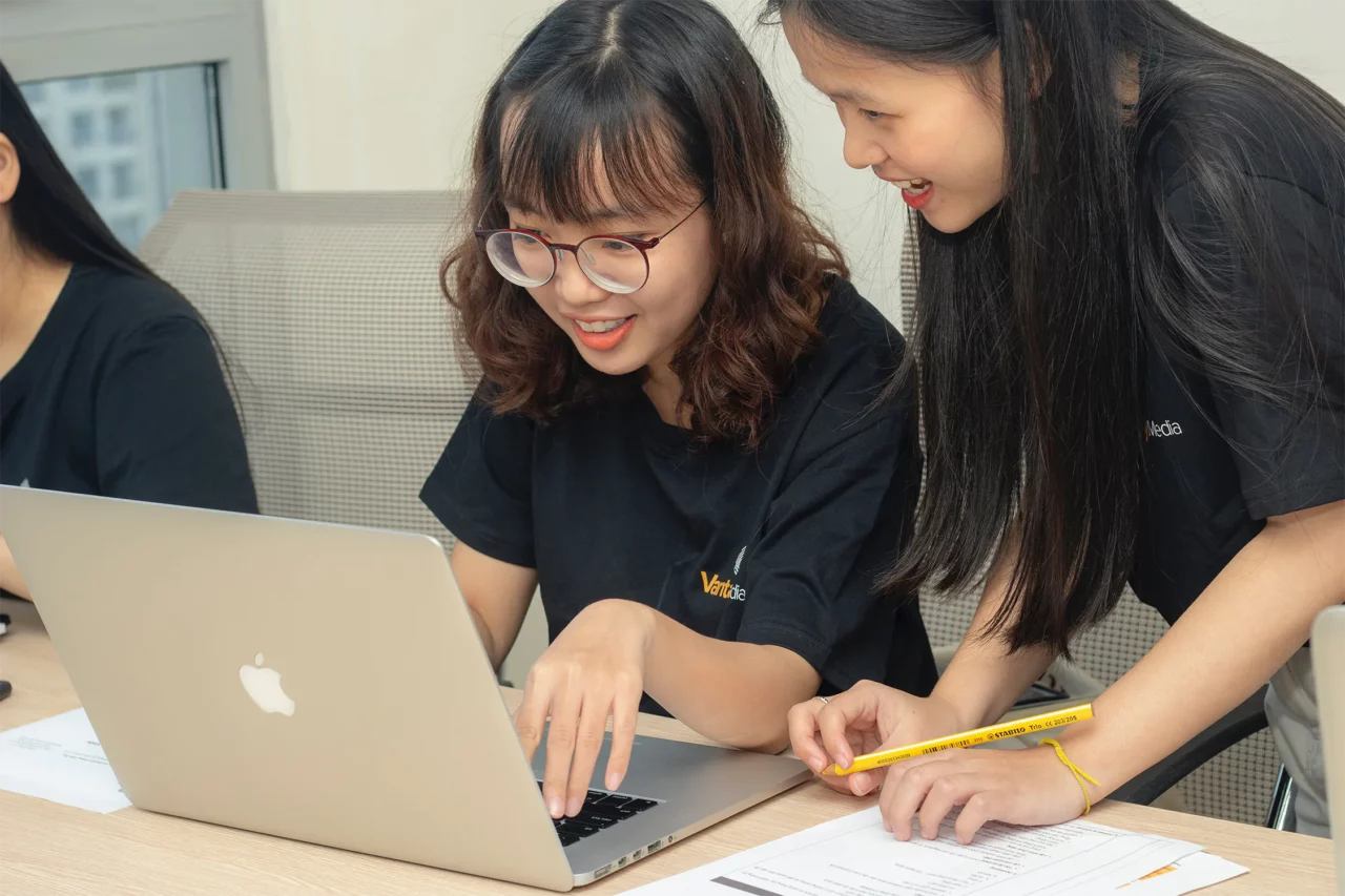 two girls in front of a computer smiling